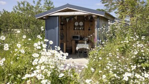 A rustic cabin with a wooden exterior, a metal roof, and a small porch area.