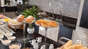 A breakfast buffet with various breads, pastries, and condiments. - Prosper Executive Hotel (Capivari)