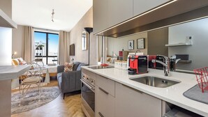 Een moderne keuken met een groot kookeiland, roestvrijstalen apparatuur en uitzicht op de stad.