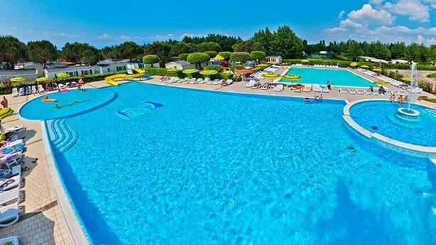 A large outdoor swimming pool with multiple lanes, a water slide, and lounge chairs. - Vacation village Le Palme Mobilehome Lodge Comfort for 5 persons (Pacengo di Lazise)