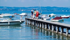A pier with boats docked and people standing on it. - Vacation village Le Palme Mobilehome Lodge Comfort for 5 persons (Pacengo di Lazise)