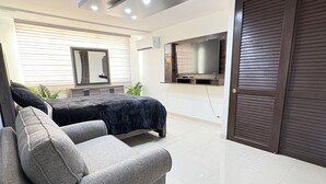 A modern living room with a sofa, a flat-screen TV, and a sliding door. - Relaxing House just 5 minutes form the San Juan Airport (Carolina)