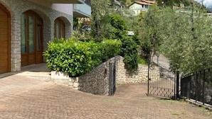 Un bâtiment en pierre doté d’une cour pavée, d’un mur en pierre et d’une porte.