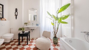 A bathroom with a checkered floor, a white sink, a mirror, a toilet, a bathtub, and a potted plant. - The Fresco Tale a Charming 3 Bedrooms Apartment (Lucca)