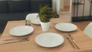 A dining table with white plates, cutlery, and a potted plant. - GO&REST APARTMENTS (València)