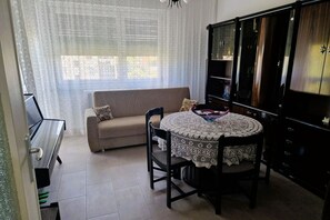 A dining area with a round table, chairs, a sofa, and a cabinet. - GuestHost - Comfortable Apartment Vallette Turin (Turin)