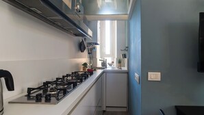Eine moderne Küche mit Gasherd, Spüle und einem Fenster, das für natürliches Licht sorgt.