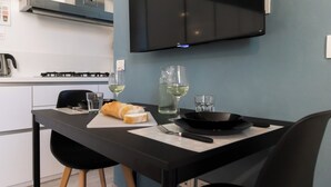 Eine moderne Küche mit Esstisch für zwei Personen, ausgestattet mit einem Baguette, Weingläsern und einer schwarzen Pfanne.