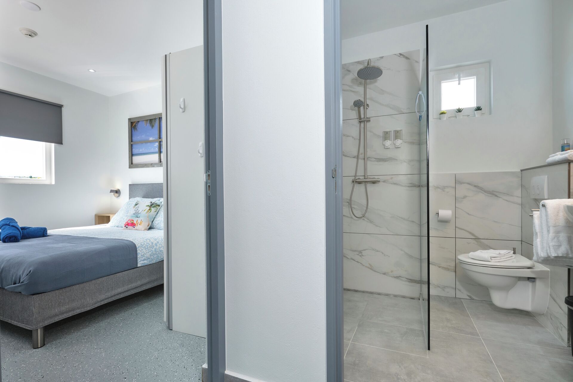 A modern bedroom with a bed, a bedside table, and a window.