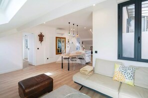 A spacious living area with a sofa, ottoman, dining table, and chairs. - Monaco Border - 100% new with see view (Beausoleil)