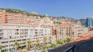 A coastal cityscape with multi-story buildings, a prominent hotel with balconies, and a clear view of the sea. - Monaco Border - 100% new with see view (Beausoleil)