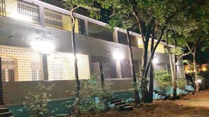 A building with multiple windows, some with metal grilles, and a staircase leading to an upper level. - The Imperial Heritage (Lonavala)