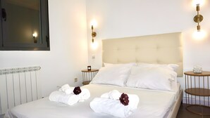 Ein Hotelzimmer mit einem Bett, zwei Nachttischen, einer Wandleuchte und einer Heizung.