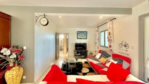 Un salon moderne avec un canapé, un téléviseur et un mur décoratif.