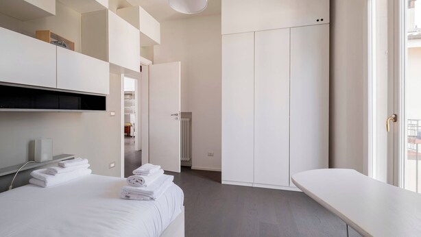 A modern hotel room with a bed, a bedside table, a wardrobe, and a view through a window. - Casa Marion Stile e Comfort in un Elegante Dimora Bolognese (Bologna)
