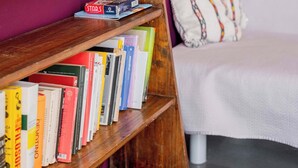 A bookshelf with books and two small cacti in a white pot. - Casa Marion Stile e Comfort in un Elegante Dimora Bolognese (Bologna)