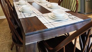A dining area with a wooden table set for four, surrounded by wooden chairs. - An explorer's escape - 3 bed 2 bath house with AC in Hico (Hico)