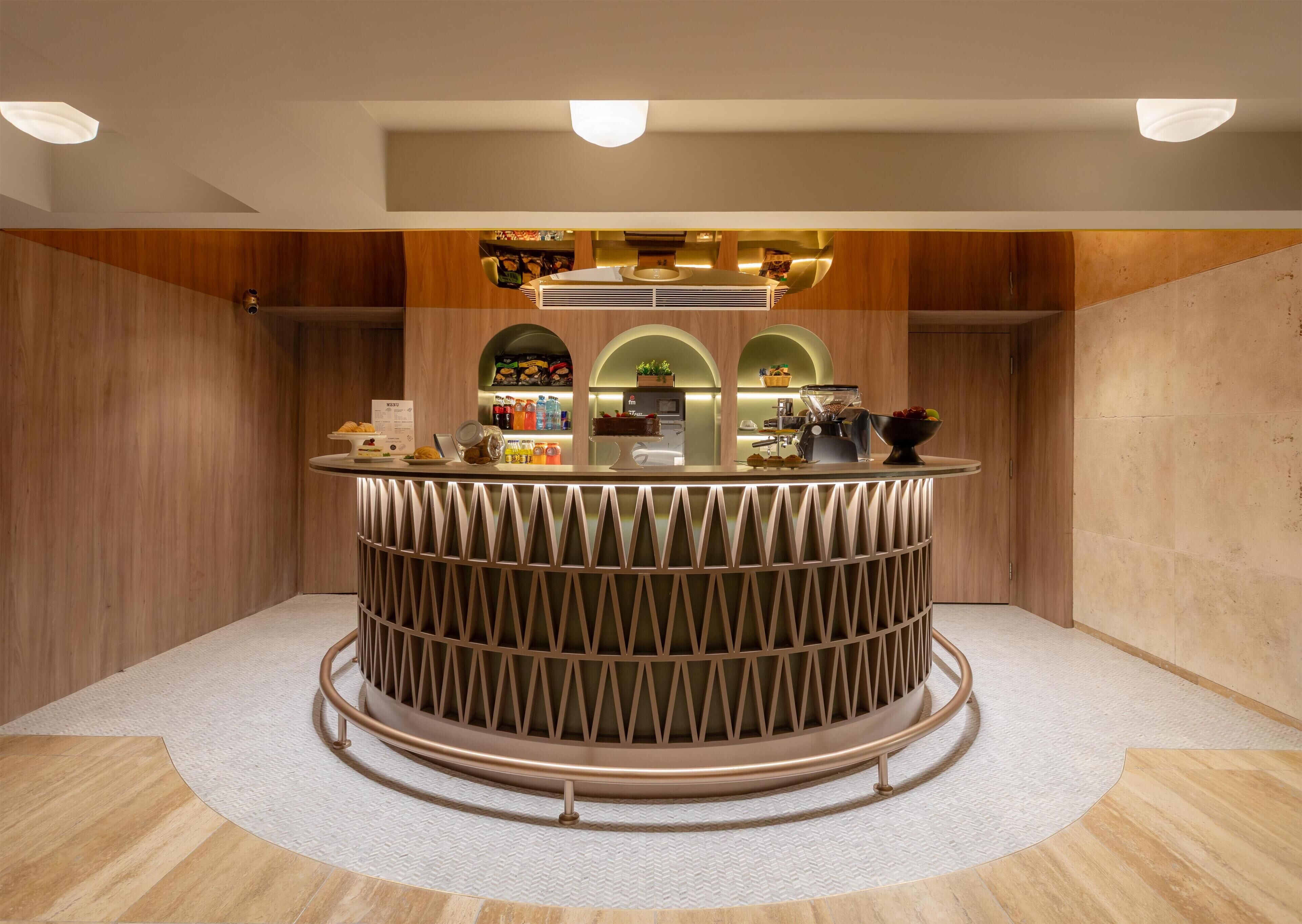 Un mostrador de recepción circular de diseño moderno, rodeado de paredes de madera y un suelo con patrón de espiga.