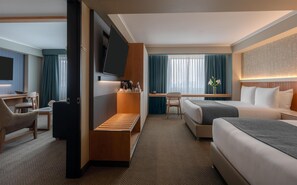 A hotel room with a bed, a desk, a chair, a TV, and a window with curtains. - Sonesta Hotel Miraflores (Lima)