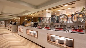 Een buffetgedeelte met verschillende stations, waaronder een koffiebar en een drankstation.