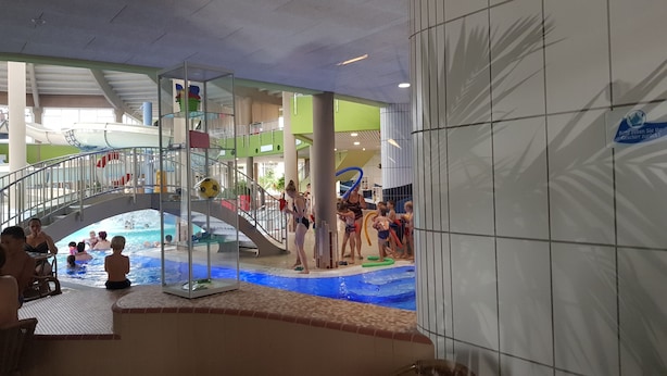 An indoor water park with a central pool, slides, and a play area. - NEW "Natur.lich Müritz" (Röbel / Müritz)