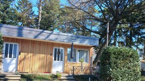 A single-story wooden cabin with a porch, a small garden, and a clear sky. - NEW "Natur.lich Müritz" (Röbel / Müritz)