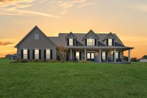 A large, two-story house with a covered porch and multiple windows. - Hot Tub + Fire Pit | Private Country Escape (Pacific)