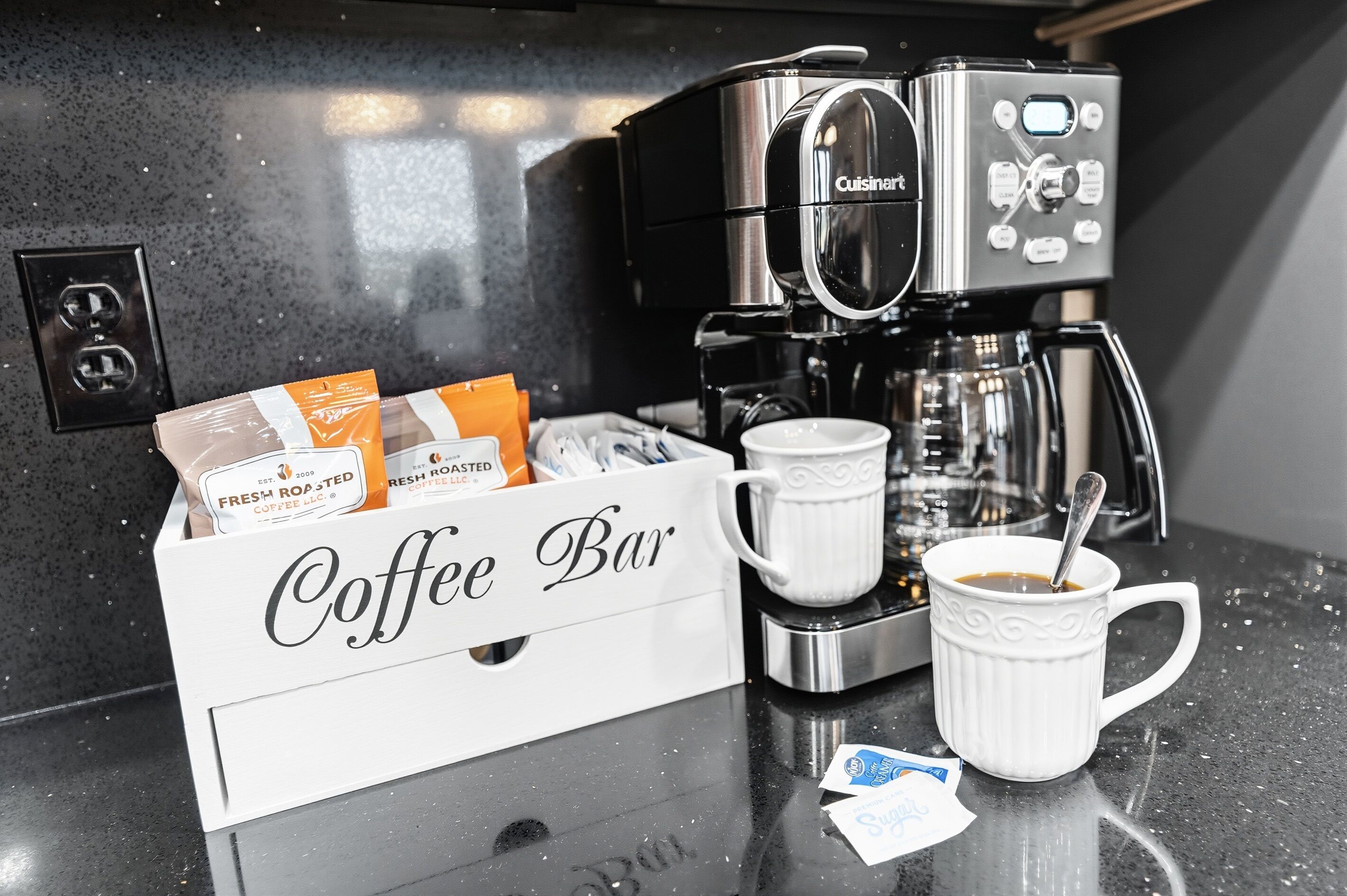Una barra de café con una máquina de café, una taza y una caja etiquetada como 