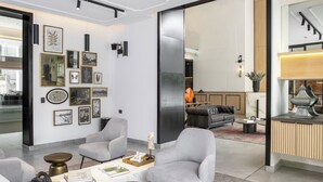 A modern interior with a seating area, a fireplace, and a kitchen counter. - Corporate Stays Somma Asturias (Santiago)