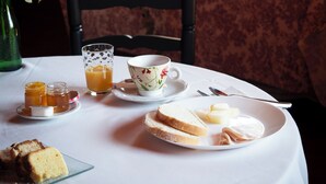 A table set for breakfast with a floral cup, glass of orange juice, bread, and jam. - hotel rural el jardin del conde (Peñacaballera)