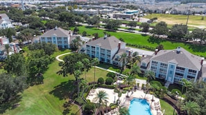 A residential area with multiple two-story houses, a swimming pool, and well-maintained lawns.
