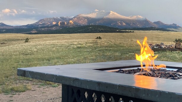 A fire pit with a mountain view in the background.