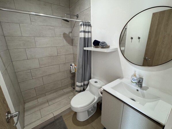 Un baño con ducha, inodoro y lavabo.
