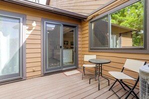 A covered patio area with a sliding glass door leading to a room, a small round table, and two chairs. - Charming 3-bedroom condo with AC in Boulder (Boulder)