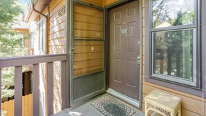 A wooden house with a brown front door, a small porch, and a window. - Charming 3-bedroom condo with AC in Boulder (Boulder)