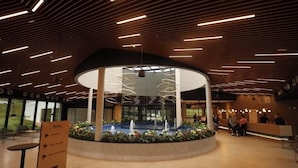 A modern lobby with a central fountain, a reception desk, and directional signage. - Ecoblue Resort Avaré (Avaré)