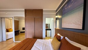 A hotel room with a large bed, a desk, and a wardrobe. There is a view of the kitchen and a bathroom in the background. - Ecoblue Resort Avaré (Avaré)