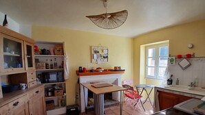 Una cocina compacta con una mesa de comedor, un microondas y una lámpara colgante.