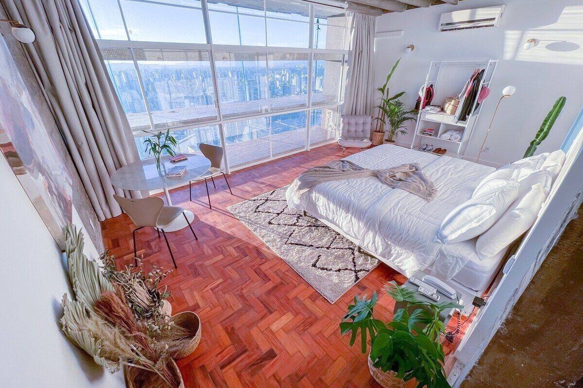 Une chambre moderne avec un grand lit, une vue sur la ville, un bureau et une chaise.