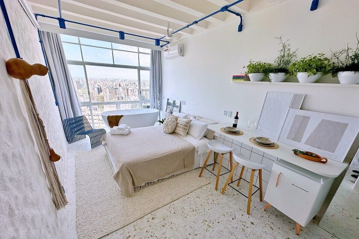 Une chambre moderne avec un lit, un bureau et une vue sur la ville.