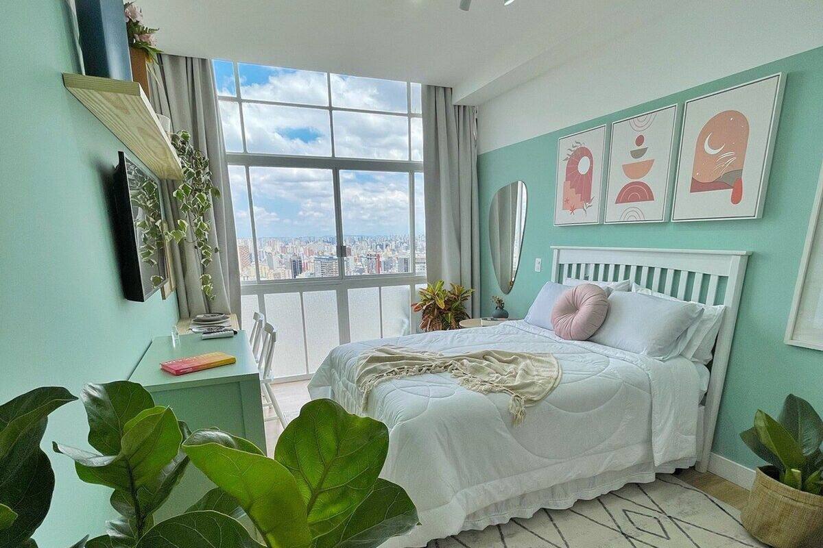 Une chambre moderne avec un grand lit, une vue sur la ville et un balcon.
