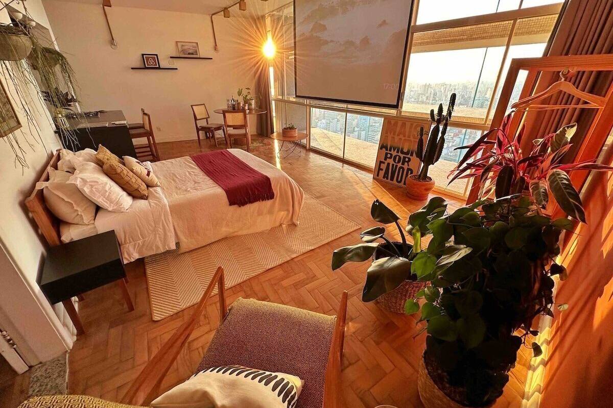 Une chambre moderne avec un lit, un bureau et une grande fenêtre.