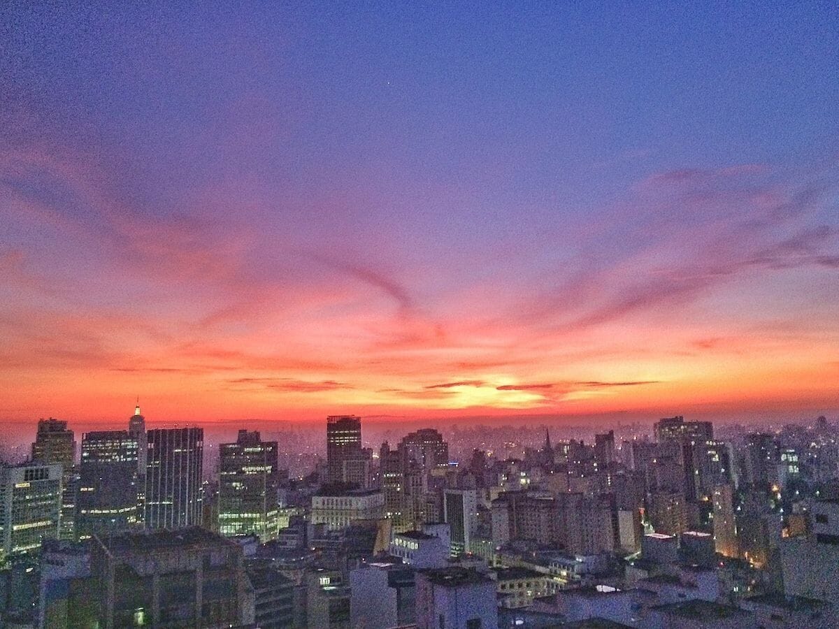 A cityscape at dusk with a skyline of high-rise buildings.