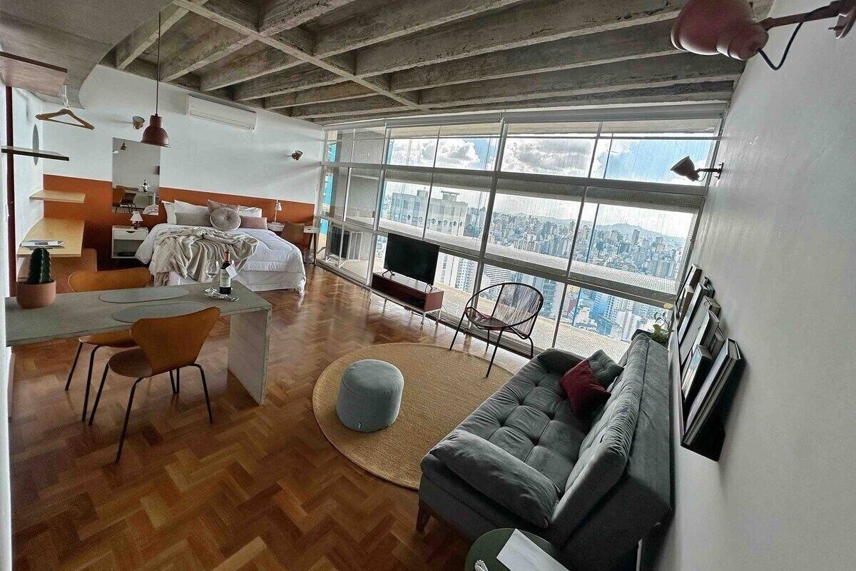 Un salon moderne comprenant un canapé, un coin repas avec des chaises, une petite table et un téléviseur.