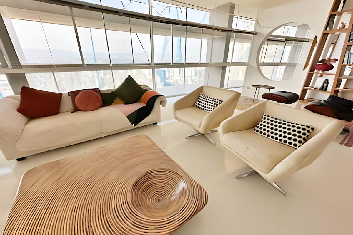 Un salon moderne comprenant un canapé, deux fauteuils et une table basse.