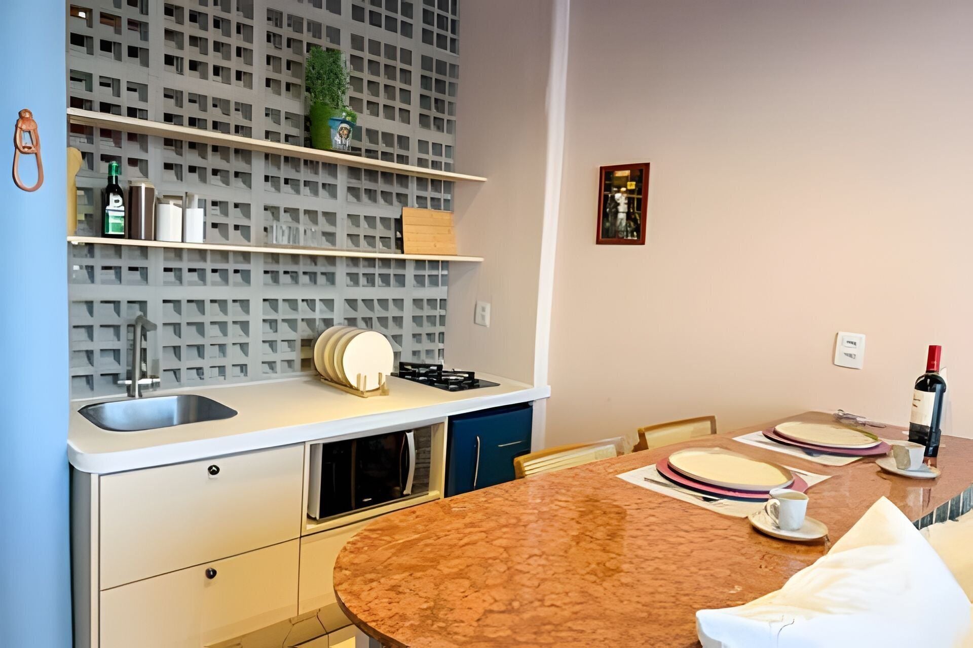 A modern kitchen with a granite countertop, built-in appliances, and a decorative wall unit.
