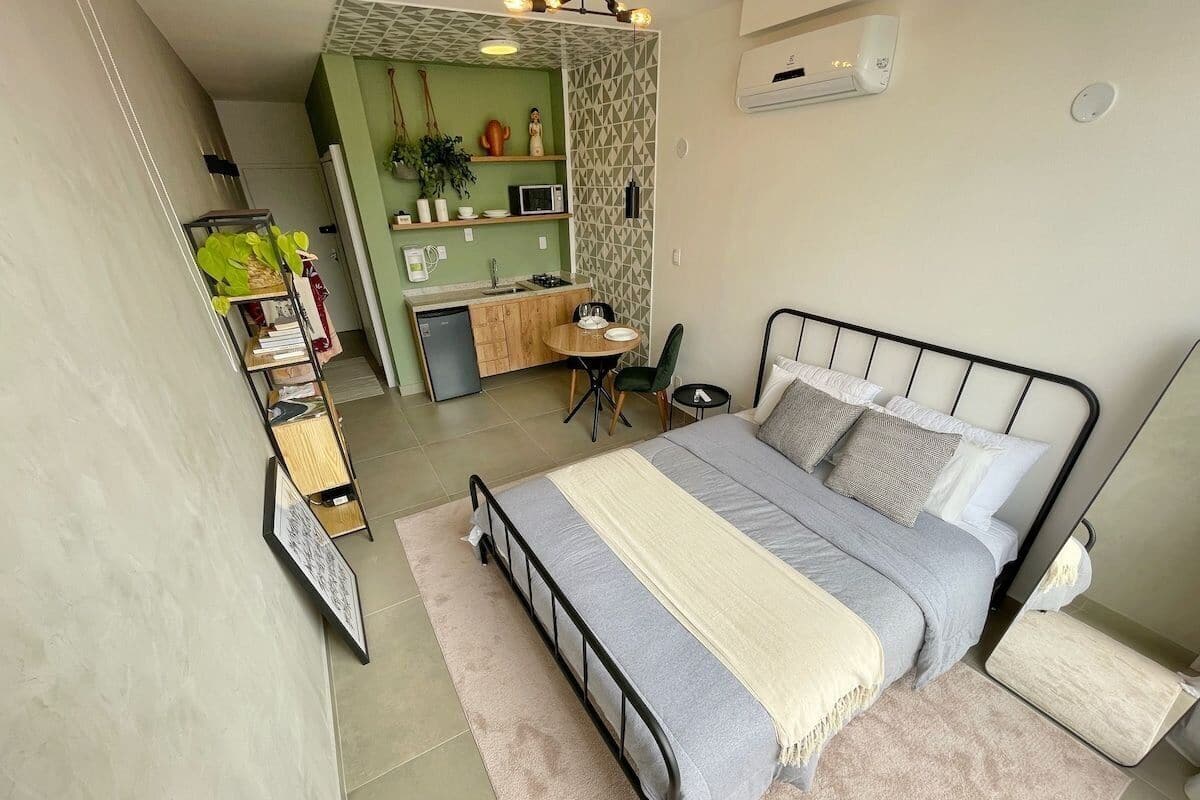 Une chambre à coucher de taille réduite, comprenant un lit, une table de chevet et un petit espace bureau.