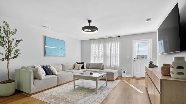 A modern living room with a sofa, coffee table, and a potted plant. - Family Fun w/Game Rm, WFH Office: 8 Min to Beach (Ocean Isle Beach)