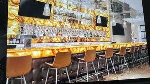 A bar area with a marble countertop, multiple bottles, and bar stools. - Marriott Grand Chateau Charming 2-bedroom Villa-Las Vegas. (Las Vegas)