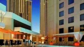 A swimming pool with lounge chairs and umbrellas, surrounded by high-rise buildings. - Marriott Grand Chateau Charming 2-bedroom Villa-Las Vegas. (Las Vegas)